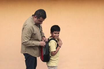Divorced single dad helps his 10-year-old Latino son with his backpack for back-to-school studies