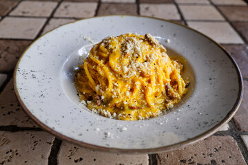 Fototapeta na wymiar Authentic Roman carbonara pasta with guanciale and pecorino on rustic ceramic plate – Rome, Italy