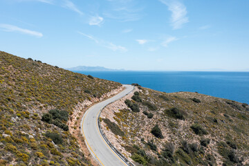 Winding coastal road hugging the hillside, revealing breathtaking views of the sparkling...