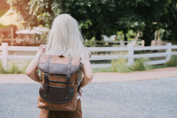 Backpacker concept. Young Girl with Backpack Facing Nature in a Scenic Outdoor Setting During a...