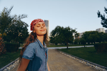 lifestyle woman in modern boho-western denim street style with bandana enjoying sunny day outdoors,...