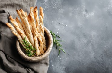 A bowl of organic Italian grissini breadsticks is paired with fresh tomatoes and olive oil, creating a classic Italian snack for apero, set against a gray background and incorporating healthy