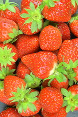 Macro shot of ripe red strawberries on a black backdrop. Ripe strawberries on a black slate backdrop. Close-up and view from above. Concept of healthy lifestyle and seasonal fruit