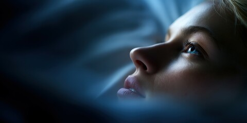 Fototapeta premium Woman looking up in bed in the dark at nighttime