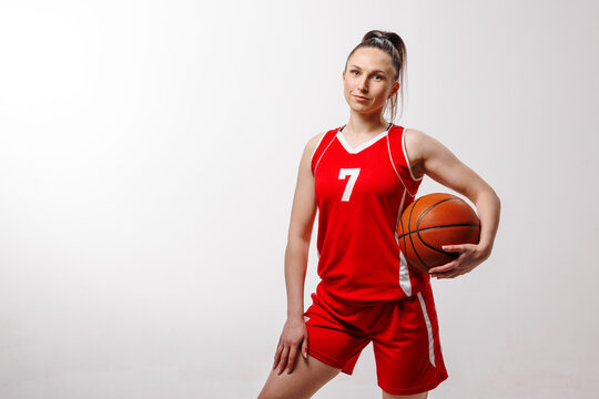 Young woman basketball player in sports uniform ready for lesson, professional training or competition, symbolizing strength and confidence.
