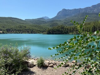 Mountain lake with turquoise water surrounded by rocky peaks and natural landscape. Crystal-clear...