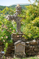 stone cross entangled in rose bushes
