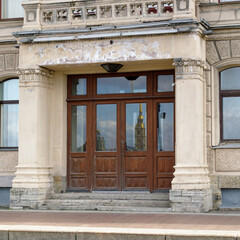 The reflection of the Peter and Paul Fortress can be seen in the wooden doors of a historic building in Saint Petersburg.
