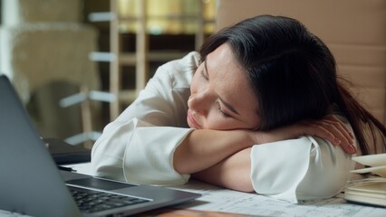 Tired Asian business woman businesswoman sleeping on office table exhausted sleepy napping girl...