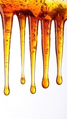 Warm Amber Resin Drips Against White Backdrop Showing Liquid Texture and Golden Hues