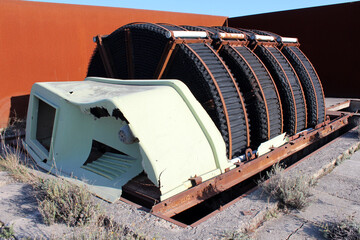 A large, weathered rotary drum filter with a corroded metal frame and faded fiberglass cover sits...