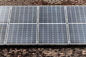 Detailed close-up of solar panels installed on a traditional brick roof, sustainable energy...