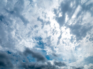 Dramatic sky filled with white and gray clouds, with patches of blue sky visible.