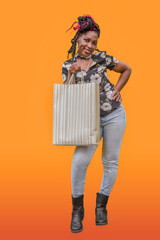 Black Woman Shopping with Striped Bag Orange Background