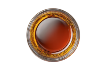 PNG Top view of whiskey glass with rich amber liquid and reflective surface