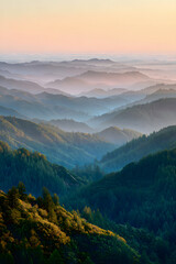 Obraz premium Breathtaking mountain range view showcases a colorful sky, forest, and fog across rolling hills at sunset or sunrise.
