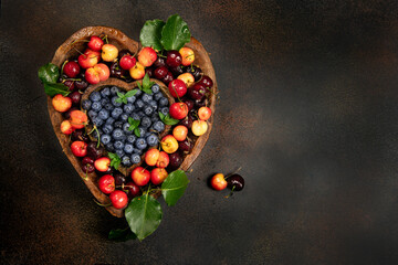 Cherries and blue berries in heart shaped bowl 