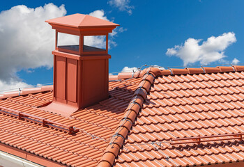 house with a roof from a red shingles with a pipe