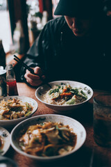 A Person Eating Noodles at an Asian Restaurant