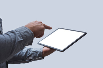 Close-up of a tablet with a blank white screen held in a man's hand against a neutral background....