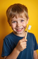 Happy boy smiles holding bamboo toothbrush. Kid prepares for teeth brushing, showing healthy white teeth. Child with dental hygiene, eco-friendly care. Smiling face, dental care, yellow background.