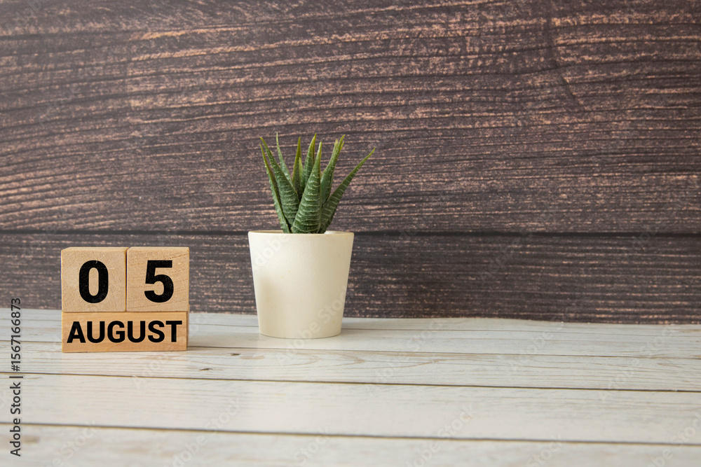 Poster wooden block calendar with the date august 05 and spikelets of wheat.