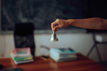 Hand of a Teacher Ringing the Bell to Start the Class. Auditory signal for class management and to...