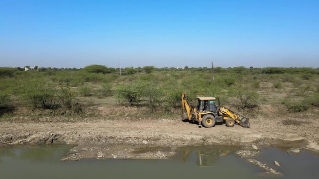 Drone View of Excavator Digging Earth in Rural Farmland Landscape, JCB