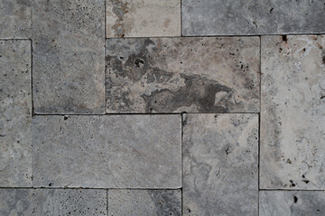 Textured background of natural stone tiles in a cool gray palette with organic patterns and pores....