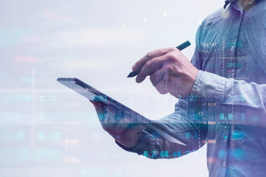 Close-up of a man in a shirt using a tablet with digital stock market data and financial graphs. Concept modern financial technology, online trading and digital analytics.