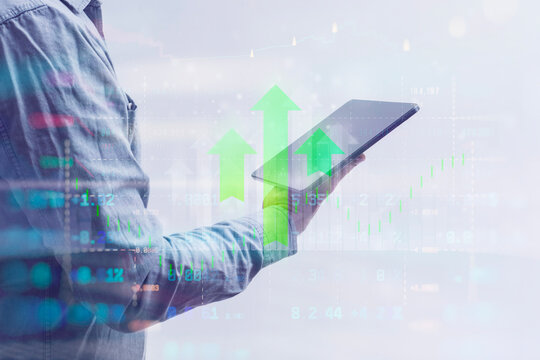 Close-up of a man in a shirt using a tablet with digital stock market data and financial graphs. Concept modern financial technology, online trading and digital analytics.