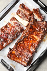 Delicious spare ribs on grey textured table, top view