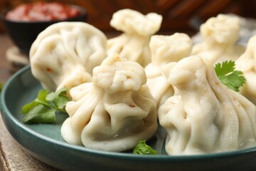Delicious khinkali with cilantro on table, closeup