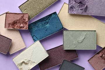 Beautiful eyeshadow refill pans on lilac background, flat lay