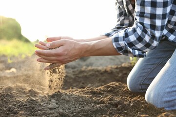 Man with pile of soil in field, closeup