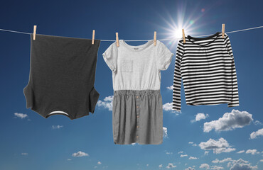 Different clothes drying on washing line against blue sky