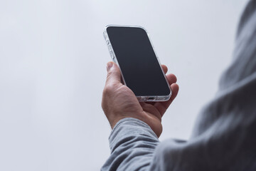 Man in shirt holding smartphone with blank screen on light background. Portable mobile technology...