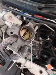 Car engine repair showing throttle body cleaning, sensor inspection, and spark plug maintenance during regular vehicle servicing