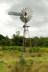 Portrait scene of an eco-friendly windmill water pump on  farm land in rural  Australia.
