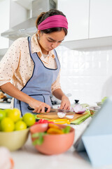 Young latin chef cutting red onions for peruvian ceviche in a modern kitchen