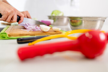 Chef slicing red onions on cutting board for peruvian ceviche preparation