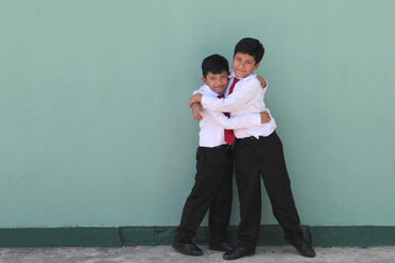 Two dark-skinned Latino boys, elementary school students in uniform, ready for back to school,...