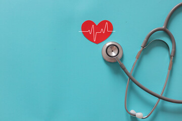 close up top view on red heart symbol and stethoscope on over blue background for design about ads or banner of insurance claim and health checkup following personal lifestyle concept