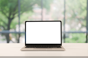  close up blank white screen display of laptop computer on table in office building with garden scene for add content of design banner,website or template or online shopping e-commerce concept