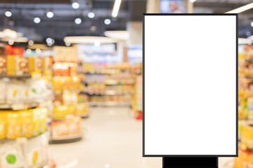 modern blank mockup poster (for ads commercial) standing over blur inside of megastore of local supermarket background in the weekend for billboard design and shopping grocery business concept