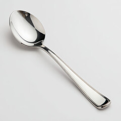 Elegant stainless steel spoon resting on a smooth white surface, ideal for culinary presentations