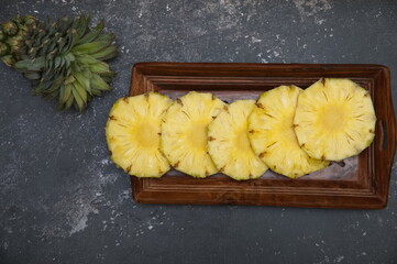 Pineapple juicy yellow slices wooden background. Top view. Pineapple fruit cut on wooden. Chopped...