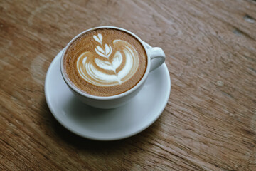 Close-up shot of a creamy latte in a white ceramic mug, evoking the warmth, comfort, relaxation and quiet enjoyment of a quiet and mindful coffee break.
