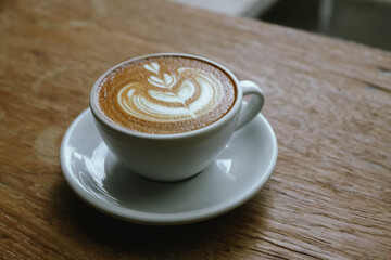 Close-up shot of a creamy latte in a white ceramic mug, evoking the warmth, comfort, relaxation and quiet enjoyment of a quiet and mindful coffee break.