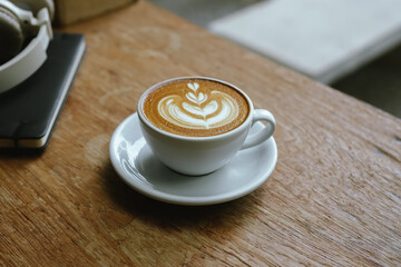 Close-up shot of a creamy latte in a white ceramic mug, evoking the warmth, comfort, relaxation and quiet enjoyment of a quiet and mindful coffee break.